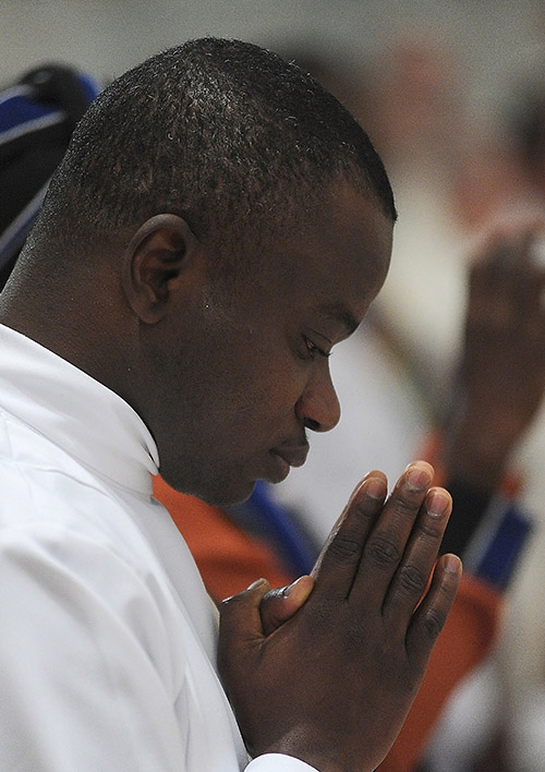 Deacon Robert Agbo prays before being ordained during the Ordination Mass at St. Joseph Cathedral. (Dan Cappellazzo/Staff Photographer)